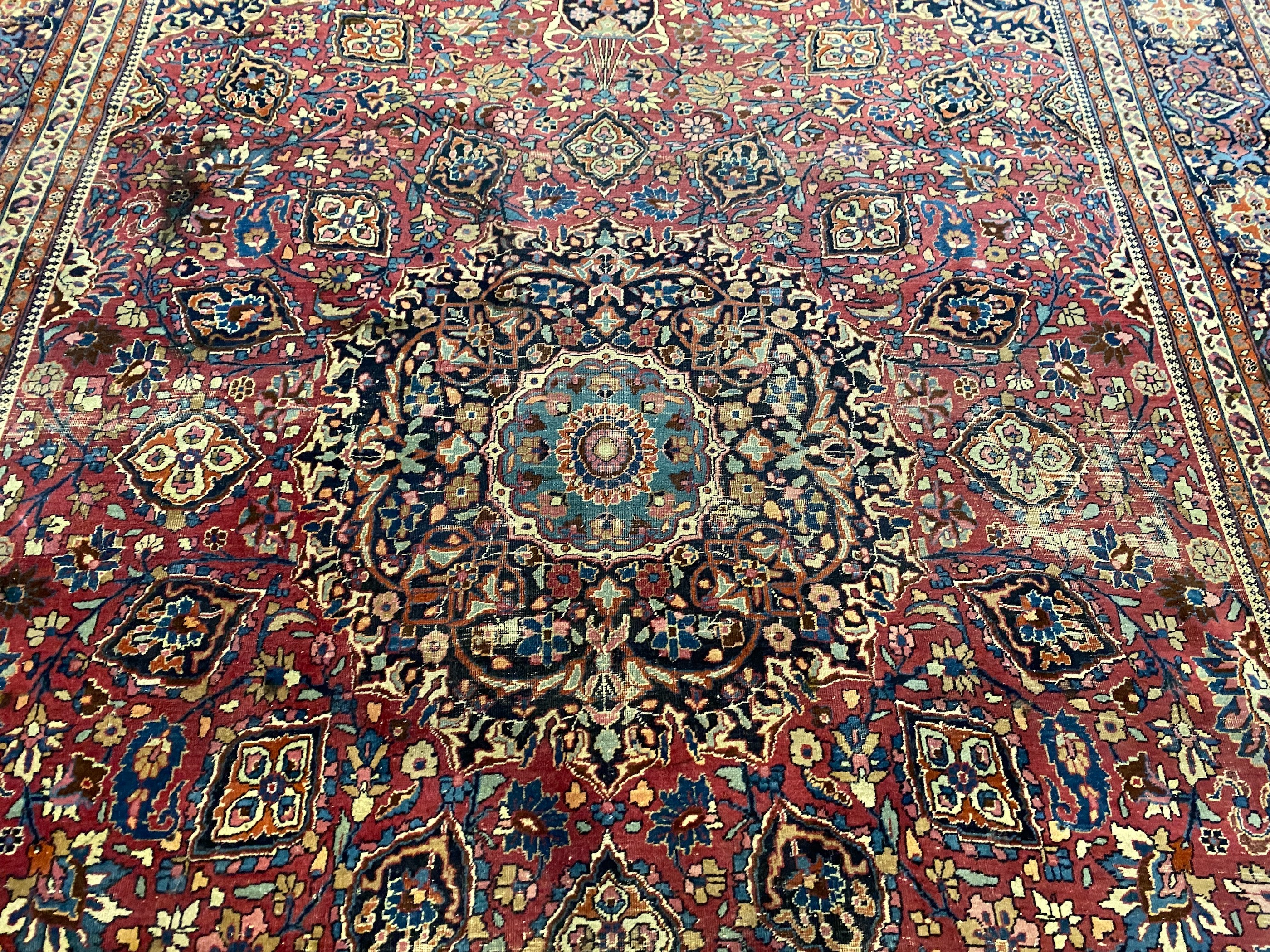 An early 20th century Heriz burgundy ground carpet, 412 x 305cm